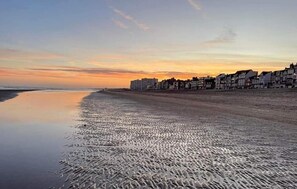 Ein Strand mit einer Reihe von Gebäuden entlang der Küste.