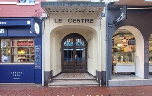The entrance to 'LE CENTRE' with a stone archway and a glass door. - Studio en plein centre-ville (Le Touquet-Paris-Plage)