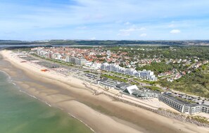 Eine Küstenstadt mit Strand, Wohnhäusern und einer Mischung aus Gewerbe- und möglicherweise Hotelgebäuden.