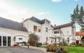 A residential building with multiple windows, a garage, and a well-maintained garden. - Lovely home in Huby Saint Leu with WiFi (Huby Saint Leu)