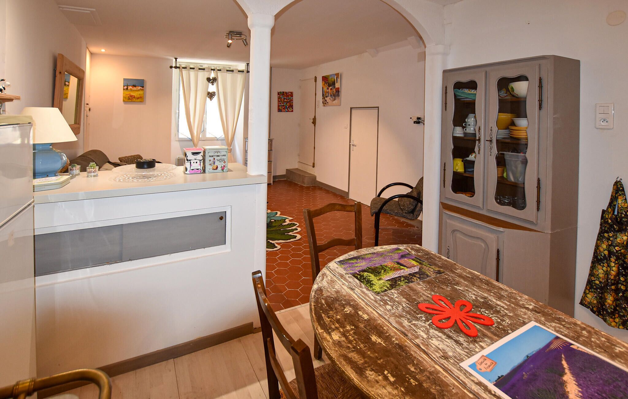 Un espace repas comprenant une table, des chaises et un buffet dont les portes sont en verre.