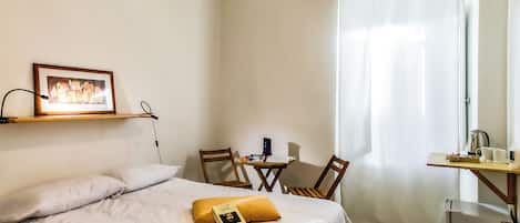 Una habitación de hotel con cama, escritorio, silla y mesa.