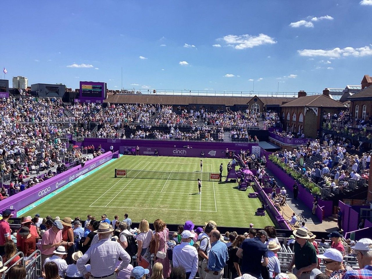 A tennis stadium with multiple tiers of seating and a central court.