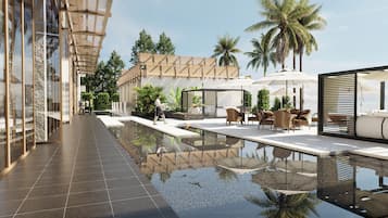 A modern outdoor pool area with seating and umbrellas, surrounded by palm trees and a building with a glass facade.