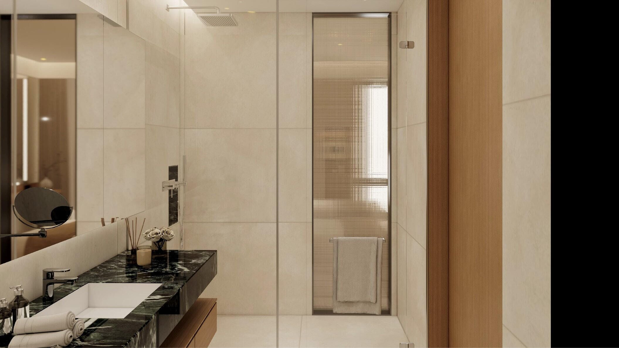 A modern bathroom with a large mirror, a marble countertop, and a glass shower enclosure.