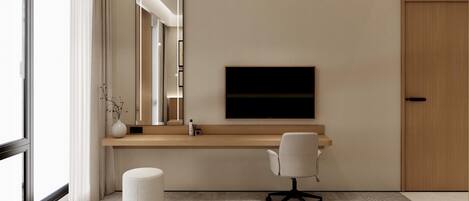 A modern hotel room with a large window, a flat-screen TV mounted on the wall, a wooden desk, a white office chair, and a round ottoman.