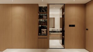 Ein modernes Interieur mit Holzvertäfelung, einer integrierten Kaffeemaschine und einer schrankhohen Spiegelwand.