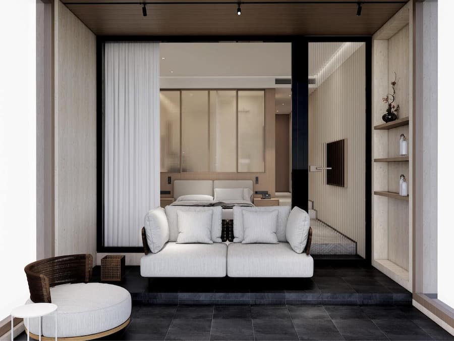 Un interior moderno con un sofá, un sillón de mimbre y una mesita.