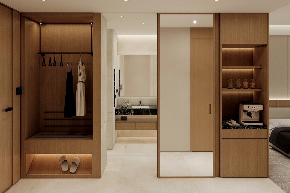 A modern bedroom with a walk-in closet, a built-in bed, and a coffee machine.