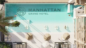 A rooftop pool area with the text 'MANHATTAN GRAND HOTEL' and a logo. There are lounge chairs and umbrellas.