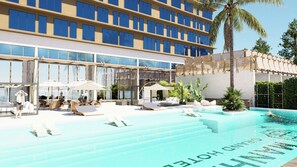 A modern hotel with a swimming pool, outdoor seating, and a large building with many windows. - Manhattan Grand Hotel (Hulhumalé)