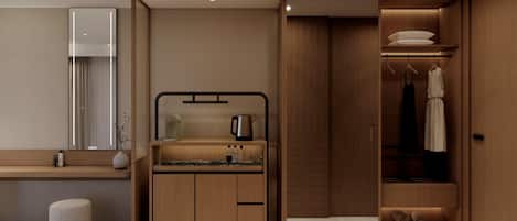 A modern bathroom with a vanity, mirror, and a walk-in closet with hanging clothes and shoes.