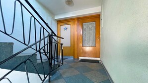 A staircase with a metal railing leading to a wooden door with a star decoration. - Spacious apartment with balcony (Boppard)