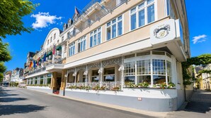 A hotel with a bay window, balconies, and flags. - Spacious apartment with balcony (Boppard)
