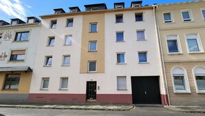 A multi-story building with a flat facade, several windows, and a black garage door. - Spacious apartment with balcony (Boppard)