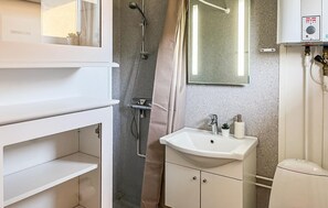 A bathroom with a shower, a sink, and a mirror. - Beautiful apartment in Nexø with sauna (Nexø)