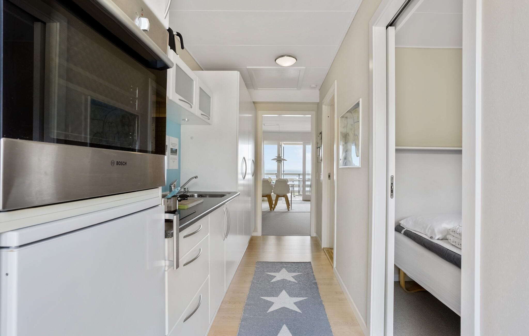 Una cocina moderna con horno Bosch, un lavamanos y un comedor con vistas.