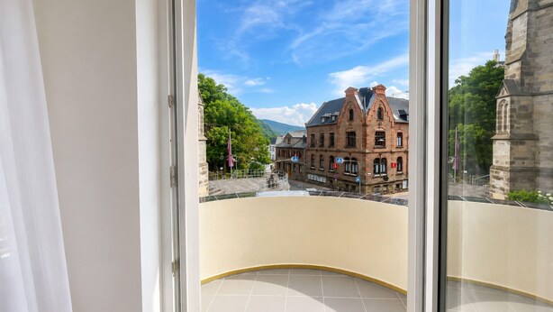 A balcony with a view of a historic building and a clear sky. - Zum Rheinberg – Balcony Suite (Braubach)
