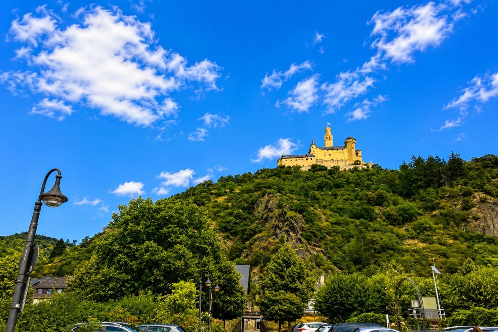 Eine Burg auf einem Hügel vor blauem Himmel.