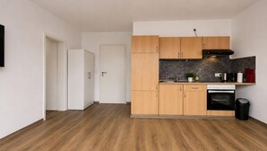 A modern kitchen with wooden cabinets, a built-in oven, and a black trash bin. - Zum Rheinberg – Balcony Suite (Braubach)
