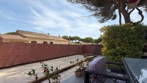 A rooftop terrace with a seating area, potted plants, and a view of buildings in the background. - Charming Villa for 6 in Agde (Agde)