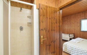 A wooden-paneled room with a shower, a bed, and a window. - Amazing home in Cailungo with WiFi (Cailungo)