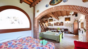 Quarto com duas camas, escada e área de refeições.