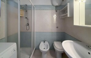 Ein Badezimmer mit Dusche, Bidet, Toilette und Waschbecken.