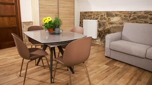 Un comedor con una mesa, sillas y un jarrón de flores.