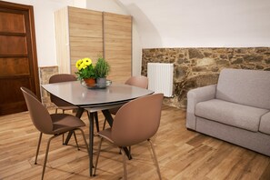 Un coin repas avec une table, des chaises et un vase à fleurs.