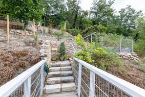 A stone staircase with metal railings leading up to a garden area with various plants and a small tree. - Holiday Home 'Hiwwelhaus' with Private Terrace, Private Garden and Wi-Fi (Oberdiebach)