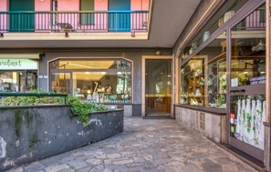 A stone-paved courtyard with a shop on the left and a large glass display on the right. - Stunning apartment in Recco with WiFi (Recco)