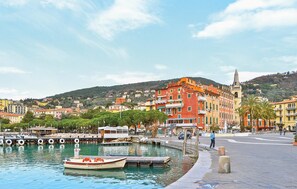 A waterfront with boats docked, buildings with balconies, and a hilly background. - Stunning apartment in Recco with WiFi (Recco)