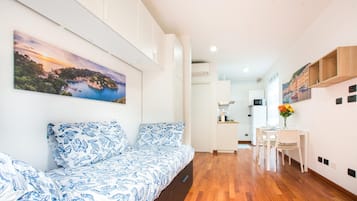 Un intérieur moderne avec un canapé, un coin repas et des œuvres d’art accrochées aux murs.