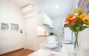 A modern kitchen with white cabinets, a built-in oven, and a stainless steel range hood.