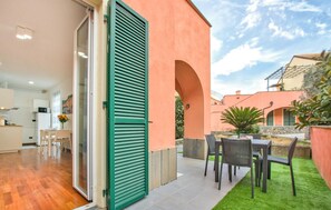 A residential property with a patio area, outdoor seating, and a view of neighboring houses.