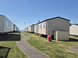 Una fila de casas móviles con un sendero pavimentado entre ellas.
