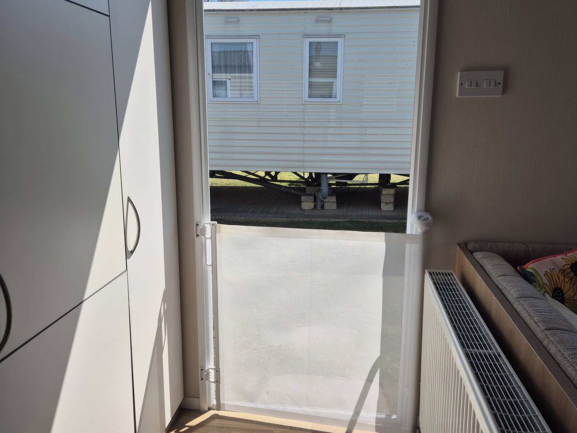 A room with a sliding door leading to a covered outdoor area, a radiator, and a window with blinds.