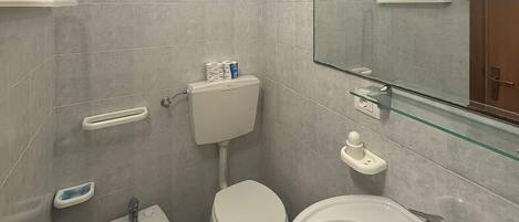 A bathroom with a toilet, bidet, and sink.
