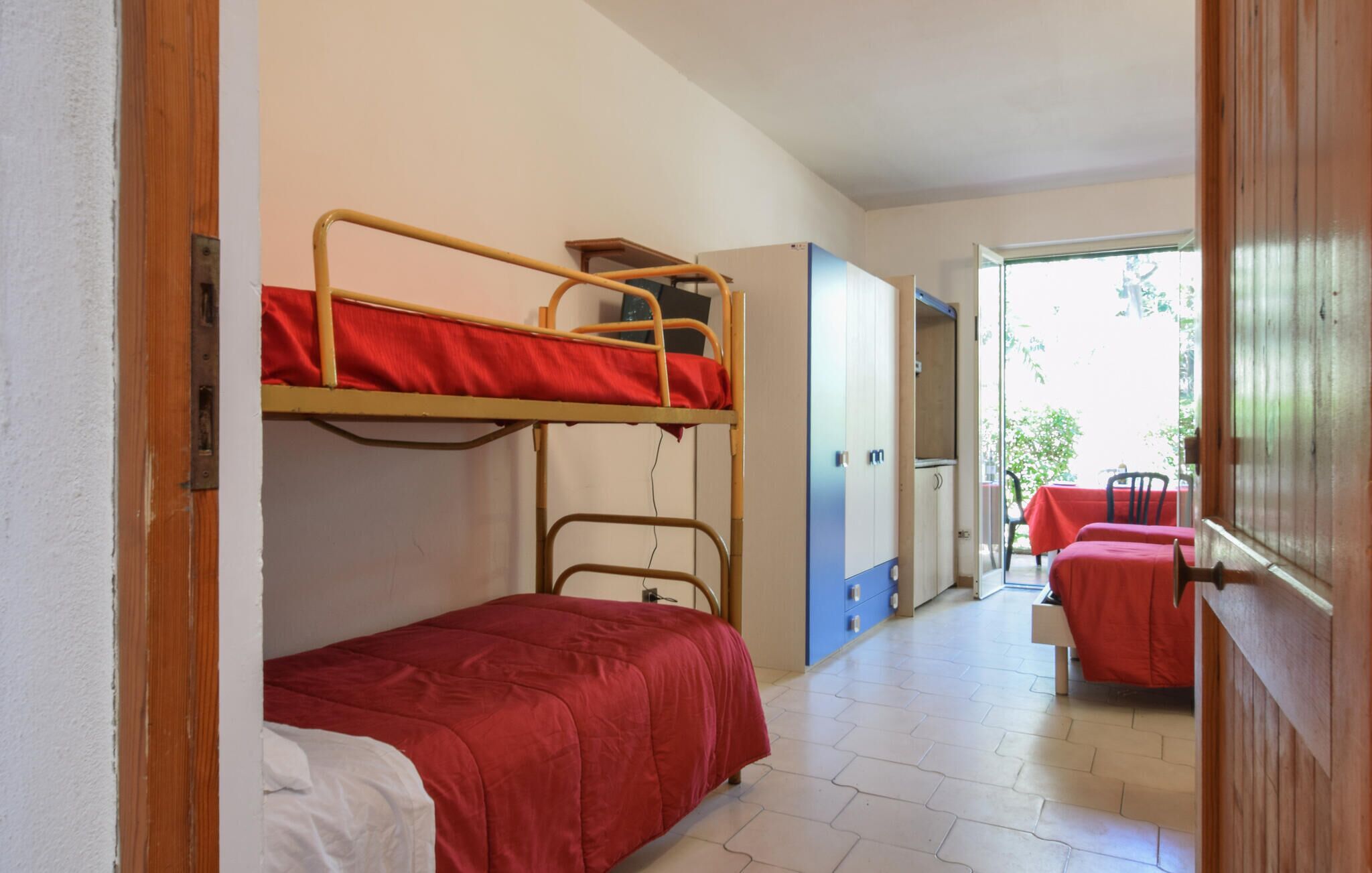 Ein Schlafsaalzimmer mit Etagenbetten, einem Schreibtisch und einem Stuhl.