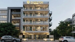 A multi-story hotel with a modern design, featuring balconies on each floor, and a sign indicating the name 'Carlton Suites'. - Hotel The Silken Stay By Carlton Suites (Gurugram)