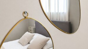 Un dormitorio con cama, almohadas y mesita de noche.