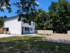 A modern two-story building with a flat roof, a small porch, and a paved driveway. - Serenity Lodge - Hammock, Nature and Tranquility (Mackenheim)