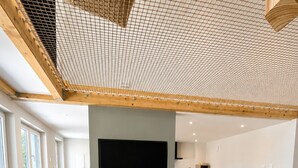 Una sala de estar moderna con televisor de pantalla plana, un sofá, una mesa de centro y una silla de madera.