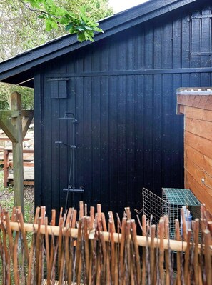 A black wooden shed with a metal door and a ladder. - Classic 1960s holiday home with Limfjord views (Fur)