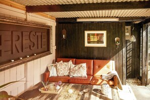 Ein gemütliches Zimmer mit einem Ledersofa, einem Holztisch und einem gerahmten Bild an der Wand.