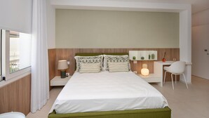 A modern hotel room with a large bed, a desk, and a chair. - Cozy apartment in Marina di Ragusa with house a panoramic view (Marina di Ragusa)