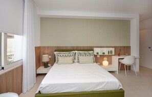 A modern hotel room with a large bed, a desk, and a chair. - Cozy apartment in Marina di Ragusa with house a panoramic view (Marina di Ragusa)