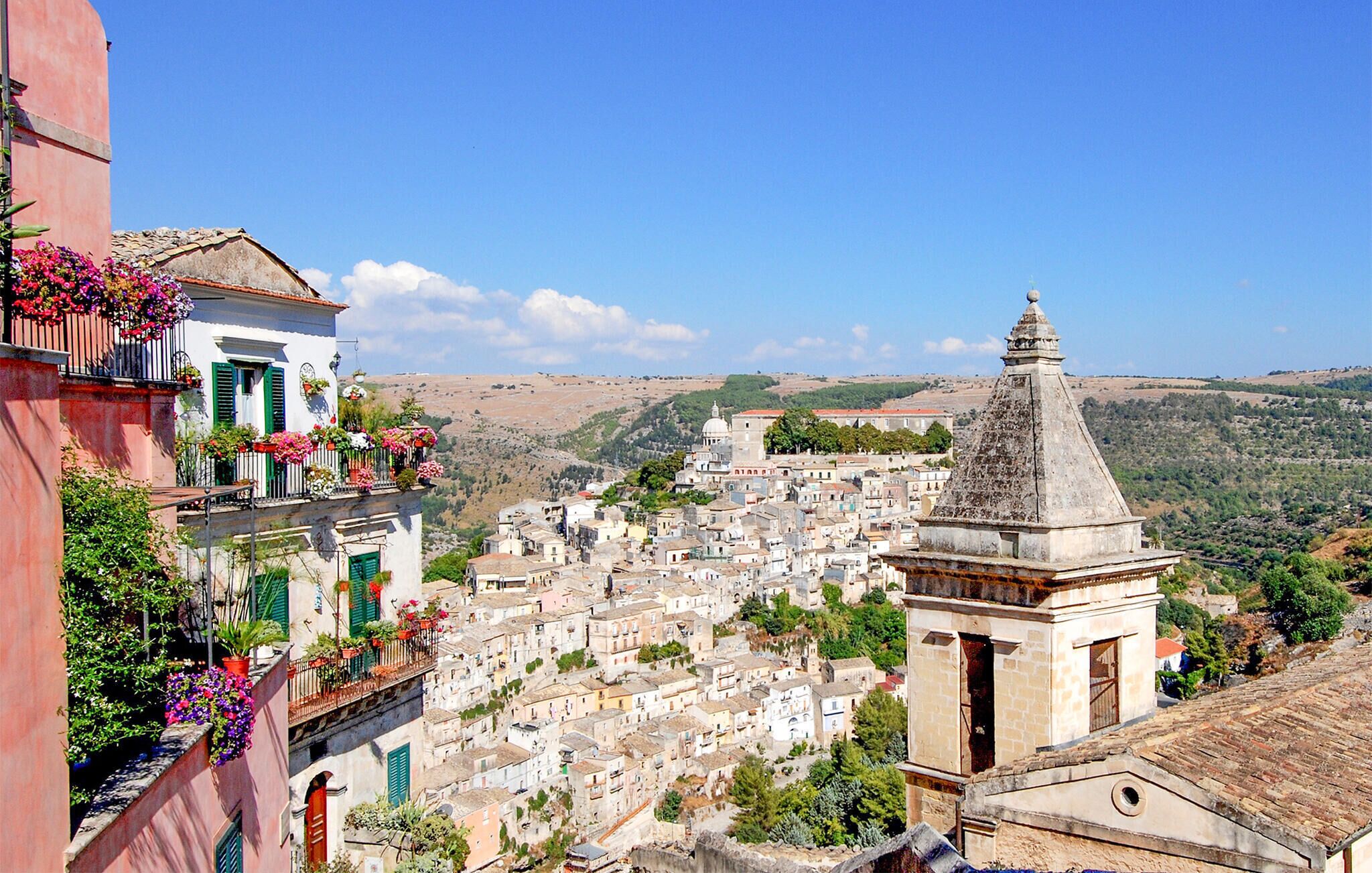 Un pueblo histórico con arquitectura tradicional, una iglesia destacada y vistas de las colinas circundantes.