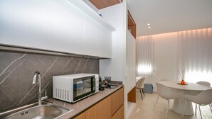 A modern kitchen with a built-in microwave, a sink, and wooden cabinets. - Stunning apartment in Marina di Ragusa with WiFi (Marina di Ragusa)